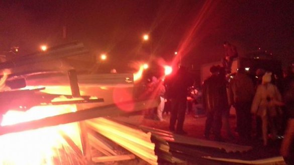 В Киеве на Осокорках снова снесли строительный забор, развели костер и подожгли строительный инвентарь В Киеве на Осокорках снова снесли строительный забор, развели костер и подожгли строительный инвентарь